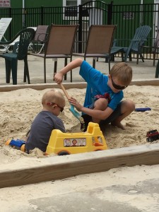 The boys playing in the sand.
