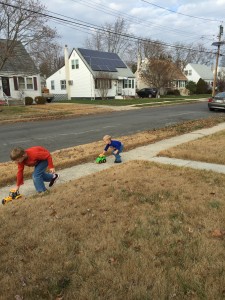 Boys playing cars outside.